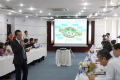 Các chuyên gia Công nghệ thông tin giới thiệu về triển khai dự án. (Ảnh: Trần Lê Lâm/Vietnam+)