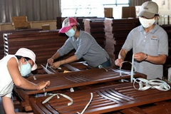 Đóng gói sản phẩm đồ gỗ xuất khẩu. (Ảnh: Trần Lê Lâm/TTXVN)