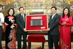 Bộ trưởng Bộ Nội vụ Trần Văn Tuấn trao tặng phiên bản khắc mộc bản Chiếu dời đô. (Ảnh: Nhật Anh/TTXVN)