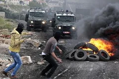 Người biểu tình Palestine ném đá vào binh sỹ Israel tại làng Kufr Qadoom. (Nguồn: THX/TTXVN)