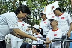 Tặng quà cho các em nhỏ nạn nhân chất độc Da cam tại một cuộc đi bộ. (Ảnh: Thế Anh/TTXVN)