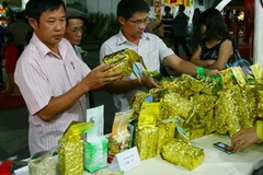 Khách tham quan gian hàng sản phẩm trà nguyên liệu của Tân Cương sản xuất theo công nghệ Đài Loan. (Ảnh: Quý Trung/TTXVN)