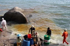 Công nhân Công ty cổ phần vận tải Việt Tín vớt váng dầu. (Nguồn: Tuổi Trẻ)