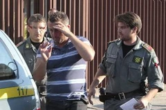 Cảnh sát áp giải một trong những kẻ bị bắt giữ trong một tổ chức mafia. (Nguồn: AFP/TTXVN)