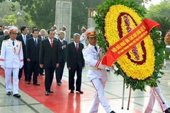 Tổng Bí thư Nông Đức Mạnh dẫn đầu Đoàn đại biểu lãnh đạo Đảng, Nhà nước, Mặt trận Tổ quốc đến đặt vòng hoa tại Đài tưởng niệm các Anh hùng Liệt sĩ. (Ảnh: Nguyễn Dân/TTXVN)