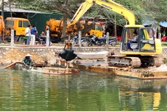 Nạo vét bùn đất hồ Trúc Bạch. (Ảnh: Bùi Tường/TTXVN)