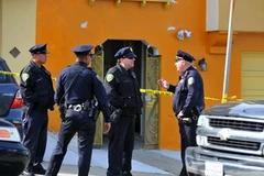 Cảnh sát phong tỏa ngôi nhà 2 tầng vừa phát hiện những xác chết. (Nguồn: THX/TTXVN)