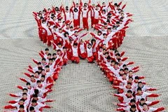 Học sinh Trung Quốc xếp thành hình ruy băng đỏ - biểu tượng của các hoạt động phòng chống HIV/ AIDS tại tỉnh Giang Tô ngày 30/11. (Nguồn: AFP/TTXVN)