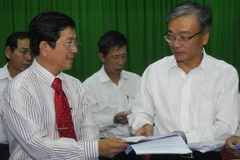 Ông Yang Kun Hsiang, Tổng giám đốc Vedan (phải) trao văn bản ký thỏa thuận cho luật sư Nguyễn Văn Hậu, đại diện nông dân Cần Giờ. (Ảnh: Hoàng Hải/TTXVN)