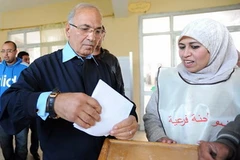 Cựu Thủ tướng Ai Cập Ahmed Mohamed Shafik (trái) bỏ phiếu tại điểm bầu cử ở Cairo, ngày 28/11. (Nguồn: THX/TTXVN)