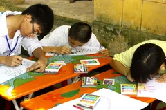 Các em học sinh khiếm thị tham gia thi vẽ tranh tại một chương trình giao lưu. (Ảnh: Bích Ngọc/TTXVN)