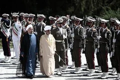 Tổng thống Iran Hassan Rowhani (trái) và Quốc vương Qaboos bin Said (phải) duyệt đội danh dự tại lễ đón ở Tehran. (Nguồn: AFP/TTXVN)