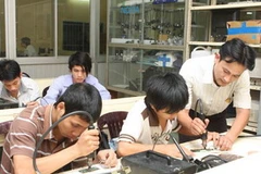 Hướng dẫn thực hành sửa chữa điện thoại. (Ảnh: Hà Thái/TTXVN) 