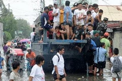Ôtô chở người dân khỏi vùng ngập lụt ở Navotas, ngoại ô Manila ngày 2/8. (Nguồn: AFP/TTXVN)