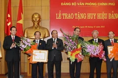Phó Thủ tướng Nguyễn Xuân Phúc trao Huy hiệu 30 năm tuổi Đảng cho các đảng viên. (Ảnh: Phương Hoa/TTXVN)