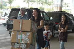 Việt kiều về quê ăn Tết qua cửa khẩu sân bay Tân Sơn Nhất. (Ảnh: Thanh Phàn-/TTXVN) 