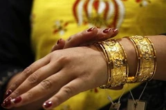 Một phụ nữ Ấn Độ lựa chọn vòng vàng tại cửa hàng trang sức ở Ấn Độ. (Nguồn: AP)