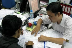 Đại diện doanh nghiệp làm thủ tục in hóa đơn. (Ảnh: Thế Anh/TTXVN)