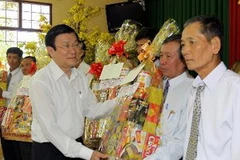 Chủ tịch nước Trương Tấn Sang tặng quà cho bà con nông dân tiêu biểu của xã Hòa An trong phong trào xây dựng nông thôn mới. (Ảnh: Thanh Vũ/TTXVN)