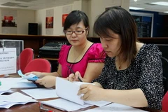 Kiểm tra tính hợp lệ của phiếu đấu thầu. (Ảnh: Phạm Hậu/TTXVN)