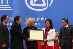 Bà Katherine Muller rao bằng Di sản phi vật thể của UNESCO cho Hội Gióng đền Phù Đổng và đền Sóc cho đại diện thành phố Hà Nội. (Ảnh: Nhật Anh/TTXVN)