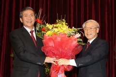 Tổng Bí thư Nguyễn Phú Trọng tặng hoa chúc mừng ông Đinh Thế Huynh, Ủy viên Bộ Chính trị, Bí thư TƯ Đảng, Trưởng Ban Tuyên giáo Trung ương, Chủ tịch Hội đồng Lý luận Trung ương nhiệm kỳ 2011- 2015. (Ảnh: Trí Dũng/TTXVN)