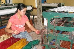 Lao động của hợp tác xã đang dệt chiếu cói bằng máy. (Ảnh: Viết Ý/TTXVN)