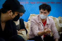 Nghệ sỹ Xuân Bắc cùng các diễn viên trẻ tham gia đóng gói những phần quà gửi tặng người khó khăn trong dịch bệnh. (Ảnh: Minh Hiếu/Vietnam+)