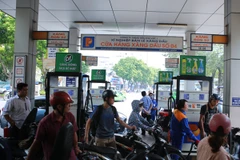 Nhân viên Petrolimex đang bán xăng cho khách hàng (Ảnh: PV/Vietnam+)