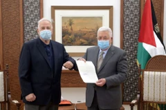 Tổng thống Palestine Mahmoud Abbas trao sắc lệnh bầu cử cho Chủ tịch Ủy ban Bầu cử Trung ương Palestine Hana Naser ở Ramallah thuộc Bờ Tây do Israel chiếm đóng ngày 15/1. (Nguồn: Reuters)