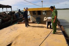 Tàu bơm hút cát trái phép trong hồ Dầu Tiếng bị lực lượng chức năng bắt giữ. (Ảnh: Lê Đức Hoảnh/TTXVN)