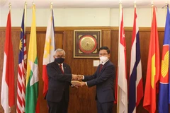 Đại sứ Việt Nam Hoàng Văn Lợi (phải) bàn giao vai trò Chủ tịch Ủy ban ASEAN tại Pretoria (APC) 2021 cho Đại sứ Indonesia Salman Al Farisi (trái). (Ảnh: Đình Lượng/TTXVN)