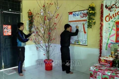 Học viên thi viết báo tường với chủ đề Mừng Đảng - Mừng Xuân. (Ảnh: TTXVN)