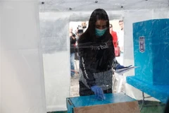 Nhân viên tại điểm bỏ phiếu ở thành phố Tel Aviv, Israel đeo khẩu trang phòng dịch viêm đường hô hấp cấp COVID-19 ngày 1/3/2020. (Ảnh: THX/TTXVN)