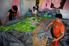 Công nhân may đồ bảo hộ y tế cá nhân và khẩu trang phòng lây nhiễm COVID-19 tại Jakarta, Indonesia. (Ảnh: AFP/TTXVN)