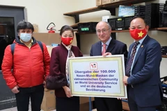Đại diện cộng đồng người Việt tại Đức trao tặng tượng trưng khẩu trang. (Ảnh: Mạnh Hùng/Vietnam+)