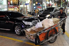 Người dân làm việc trên đường phố tại Busan, Hàn Quốc. (Ảnh: AFP/TTXVN)