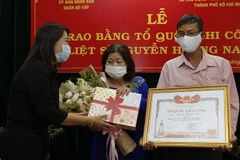 Trao quà lưu niệm cho gia đình liệt sỹ Nguyễn Hoàng Nam. (Ảnh: Thanh Vũ/TTXVN)