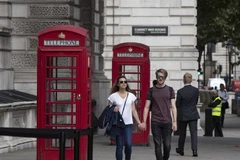 Người dân di chuyển trên đường phố tại London, Anh. (Ảnh: THX/TTXVN)