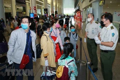 Lực lượng An ninh hàng không hướng dẫn hành khách đến khu cách ly. (Ảnh: Doãn Tấn/TTXVN)