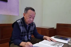 Kỹ sư Phạm Lộc đang say sưa đọc Nội san Thông tấn. (Ảnh: Đinh Thuận/TTXVN)