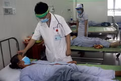 Bác sỹ đang thăm khám cho bệnh nhân bị ngộ độc thực phẩm sau khi sử dụng pate Minh Chay. (Ảnh: Trịnh Bang Nhiệm/TTXVN)