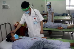 Bác sỹ đang thăm khám cho bệnh nhân bị ngộ độc thực phẩm sau khi sử dụng pate Minh Chay. (Ảnh: Trịnh Bang Nhiệm/TTXVN)