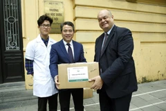 Giáo sư-Tiến sỹ Nguyễn Thanh Bình - Hiệu trưởng Trường Đại học Dược Hà Nội, trao tặng dung dịch nước rửa tay khô cho ông ERIC MOLAY – Tùy viên hợp tác khoa học và đại học, đại diện Đại sứ quán Pháp tại Việt Nam. (Ảnh: Dương Ngọc/TTXVN)