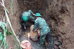 Lực lượng chức năng kiểm tra hiện trường quả bom. (Ảnh: Thanh Hải/TTXVN)
