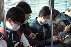 Người dân đeo khẩu trang phòng tránh lây nhiễm dịch COVID-19 tại Tokyo, Nhật Bản. (Ảnh: THX/TTXVN)