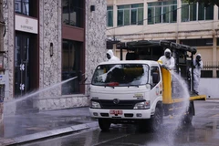Lực lượng bộ đội hóa học phun hóa chất tiêu tẩy khu vực phố Trúc Bạch, quận Ba Đình, nơi có nhà của bệnh nhân mắc COVID-19. (Ảnh: Dương Giang/TTXVN)