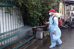 Nhân viên Y tế phun thuốc tiêu độc khử trùng. (Ảnh: Phạm Kiên/TTXVN)