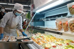 Nhân viên siêu thị bổ sung liên tục sản phẩm tươi sống lên kệ, đảm bảo đủ hàng phục vụ cho người dân. (Ảnh: Phương Anh/TTXVN)
