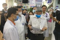 Thứ trưởng Bộ Y tế Nguyễn Trường Sơn kiểm tra quy trình thực hiện điều tra dịch tễ người bệnh tại Bệnh viện đa khoa Vạn Hạnh. (Ảnh: Đinh Hằng/TTXVN)
